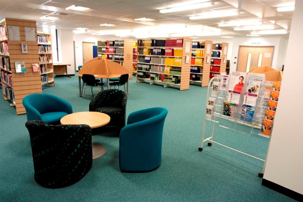 Picture of a library with books on shelves, study carousels and chairs